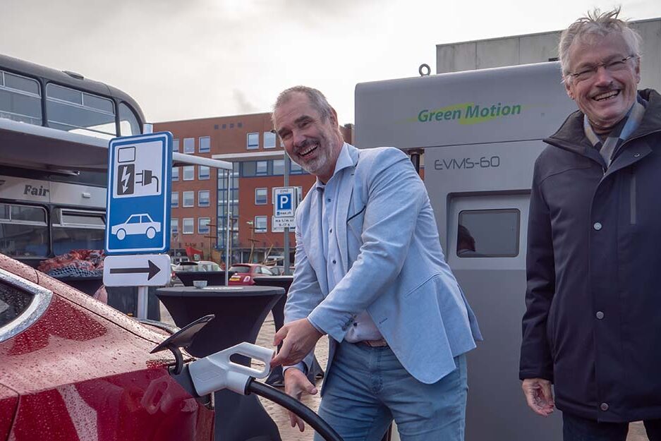 Man laad zijn Tesla op aan een oplaadpaal